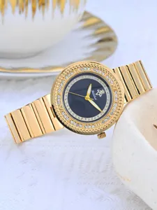 Gros plan sur la montre dorée pour femme de luxe avec un cadran en strass étincelant.