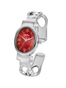 Yalalusi silver bangle watch detail showing the striking red striped dial and crystal settings.