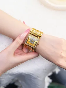 Luxus goldene quadratische Damenuhr mit funkelnden Strasssteinen und elegantem breiten Armband.
