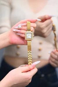 Detailed shot of the luxury square gold women's watch, showcasing the sparkly crystal bezel.