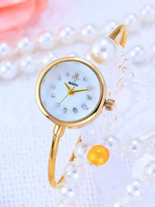 Vista di dettaglio dell'orologio rigido dorato con quadrante in madreperla e strass.