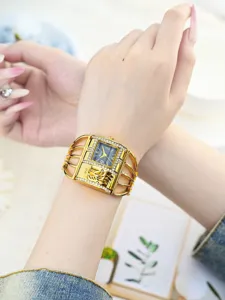 Vista detallada del elegante reloj de pulsera dorado Yalalusi para mujer con correa de jaula.