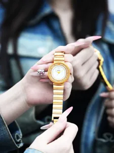 Gros plan détaillé du cadran de montre à quartz en strass doré et de son bracelet élégant.