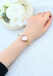 Elegante orologio bracciale con perla da donna con quadrante rosa e cinturino oro.