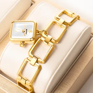Primer plano detallado de un lujoso reloj de mujer cuadrado dorado con correa de eslabones.