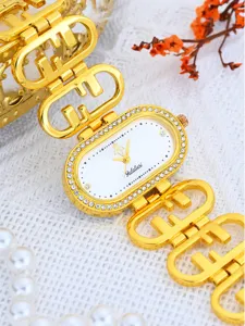 Luxury gold rhinestone oval quartz women watch with elegant chain strap and clear dial display.