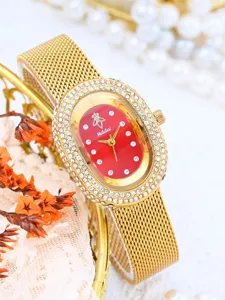 Primer plano detallado del elegante reloj dorado de mujer con esfera ovalada roja brillante.