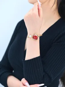 Elegante orologio bracciale dorato da donna con quadrante rosso e perla bianca unica.