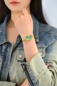 Elegante reloj de cuarzo para mujer con esfera azul pequeña, pedrería y correa dorada fina.