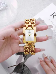 Nahaufnahme Detail der luxuriösen goldenen quadratischen Uhr mit doppelten Metallketten.