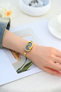 Elegante reloj de mujer con correa de acero fina, esfera pequeña y bisel de pedrería.