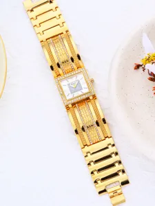 Goldene quadratische Damenuhr Detailaufnahme mit funkelndem Zifferblatt und strukturiertem Armband.