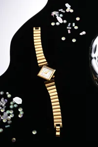 Nahaufnahme der eleganten goldenen Quarzuhr mit quadratischem Zifferblatt und Gliederarmband.