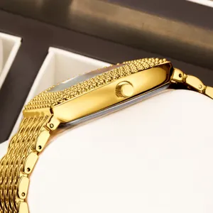 Elegant gold tonneau quartz watch for women featuring sparkling studded bezel and mesh strap.