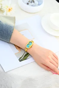 Reloj de cuarzo dorado para mujer con esfera turquesa y elegante correa de acero fina.