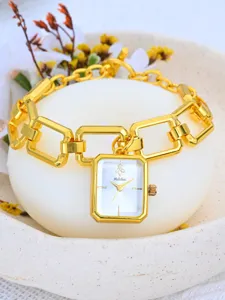 Exquisito detalle de reloj rectangular dorado con pulsera de eslabones y esfera elegante.