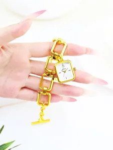 Reloj de pulsera cuadrado dorado detalle, correa de cadena calada y diseño de colgante.