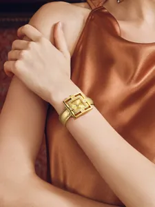 Luxury women quartz watch with gold hollow cuff bracelet strap and crystal dial details.
