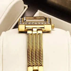 Elegant gold square quartz watch with rhinestone bezel and textured metal mesh band.