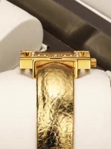 Exquisite detail of women luxury quartz watch with unique gold case and textured strap.