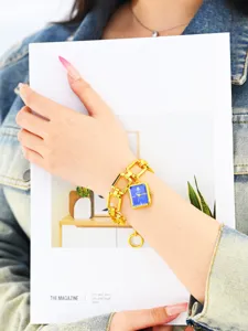 Vista detallada de un reloj de mujer cuadrado azul con una elegante correa de cadena.