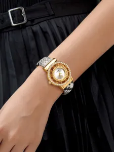 Primer plano de reloj de cuarzo para mujer con bisel calado y correa de piel de serpiente.