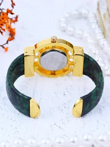 Vista detallada de reloj de cuarzo para mujer con pulsera de piel de serpiente.