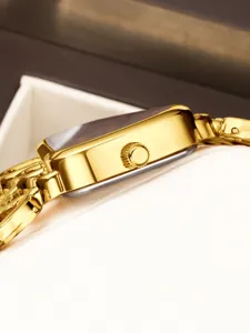 Gouden vierkante quartz dames horloge zijkant detail, elegante metalen armband en kroon.