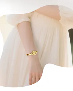 Close-up detail shot of a luxury gold bangle quartz watch worn on wrist, elegant feminine style.