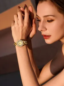 Gold chain link watch for women with sparkly diamond bezel and elegant dial design detail.