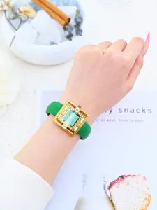 Elegant women's quartz watch with green leather strap and gold hollow rhinestone case detail.