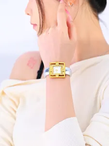 Detailed view of the women's square quartz watch worn on wrist, showing ornate gold frame.