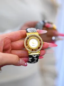 Vista detallada de reloj de cuarzo para mujer con esfera hueca de strass y correa de serpiente.