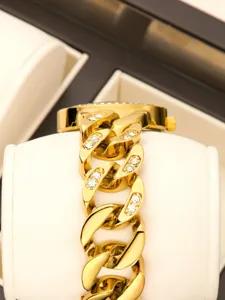 Close-up detail of luxury gold chain women's watch with dazzling rhinestones set.