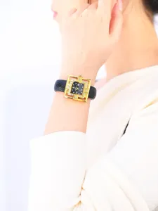 Close-up of the elegant women quartz watch with geometric crystal bezel and black leather strap.