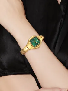 Luxury women quartz watch featuring green cushion dial, crystal markers, and gold geometric strap.
