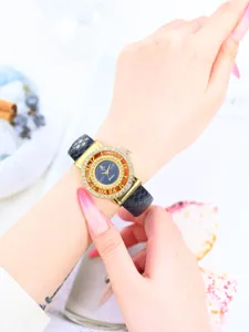 Reloj de cuarzo para mujer con esfera hueca de pedreria dorada y correa con patron de serpiente.