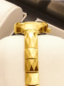 Gold faceted luxury watch detail shot showing unique geometric link bracelet and case.