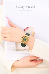Primer plano detallado de reloj de cuarzo para mujer con correa de serpiente verde y esfera.