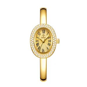 Elegant gold quartz watch for women with oval rhinestone bezel and bangle bracelet.