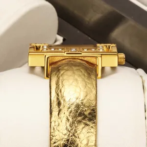 Luxury gold tone women quartz watch with textured leather strap and iconic H-shape case design.