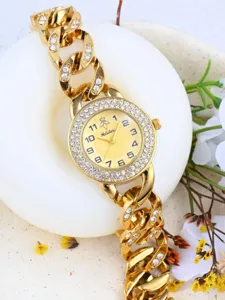 Gold rhinestone chain watch detail view, elegant luxury wristwatch with sparkling diamonds.