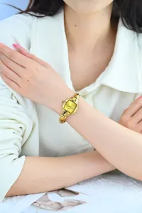 Detail shot of a vintage gold tonneau small dial women watch with exquisite metal strap.