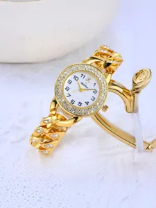 Close-up of gold chain women's watch with rhinestone bezel and white dial, elegant detailed view.