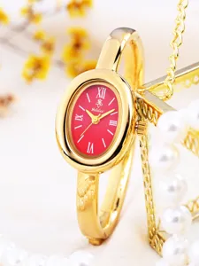Elegant gold oval bangle watch for women featuring a striking red dial and quartz movement.