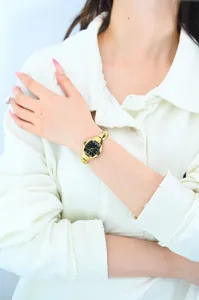 Women's vintage tonneau-shaped watch with black dial and gold strap for daily elegance