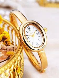 Detail view of a luxury gold oval bangle quartz watch with a white dial and roman numerals.