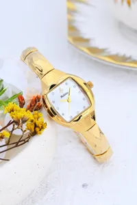 Luxury gold tonneau women quartz watch with small white dial and unique faceted band for chic style.