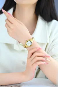 Elegant women's retro tonneau small dial watch with gold metal strap and sparkling crystal indices.