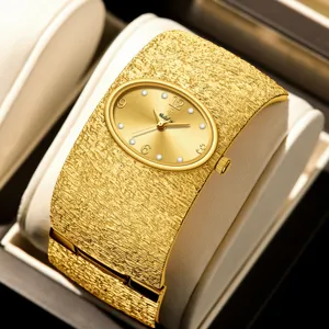 Reloj pulsera de lujo dorado para mujer con correa ancha texturizada y elegante esfera ovalada.